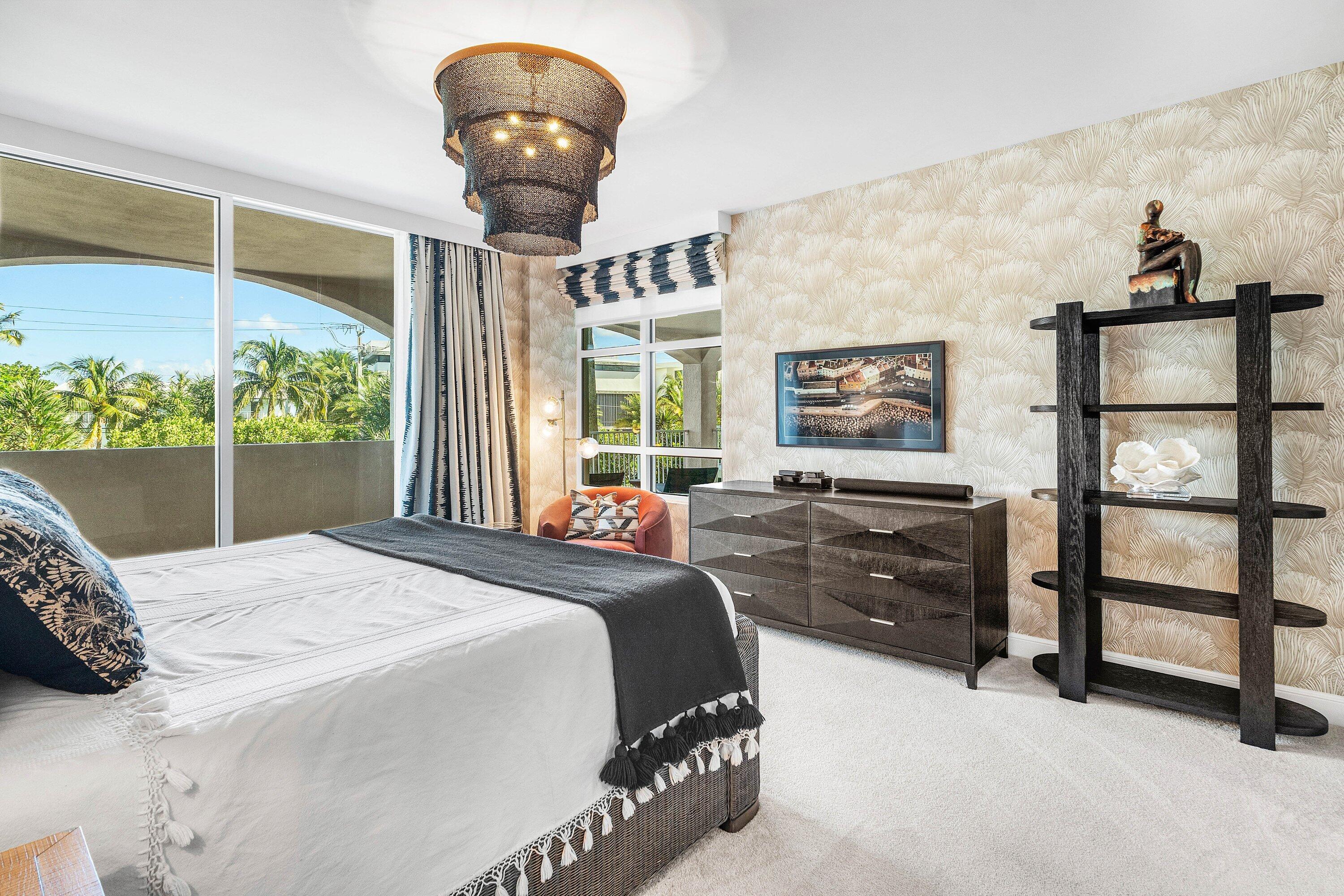 3700 South Ocean Boulevard, Unit 202 Highland Beach, FL 33487 - Photo 28 of 75 a bedroom with a bed and a chandelier