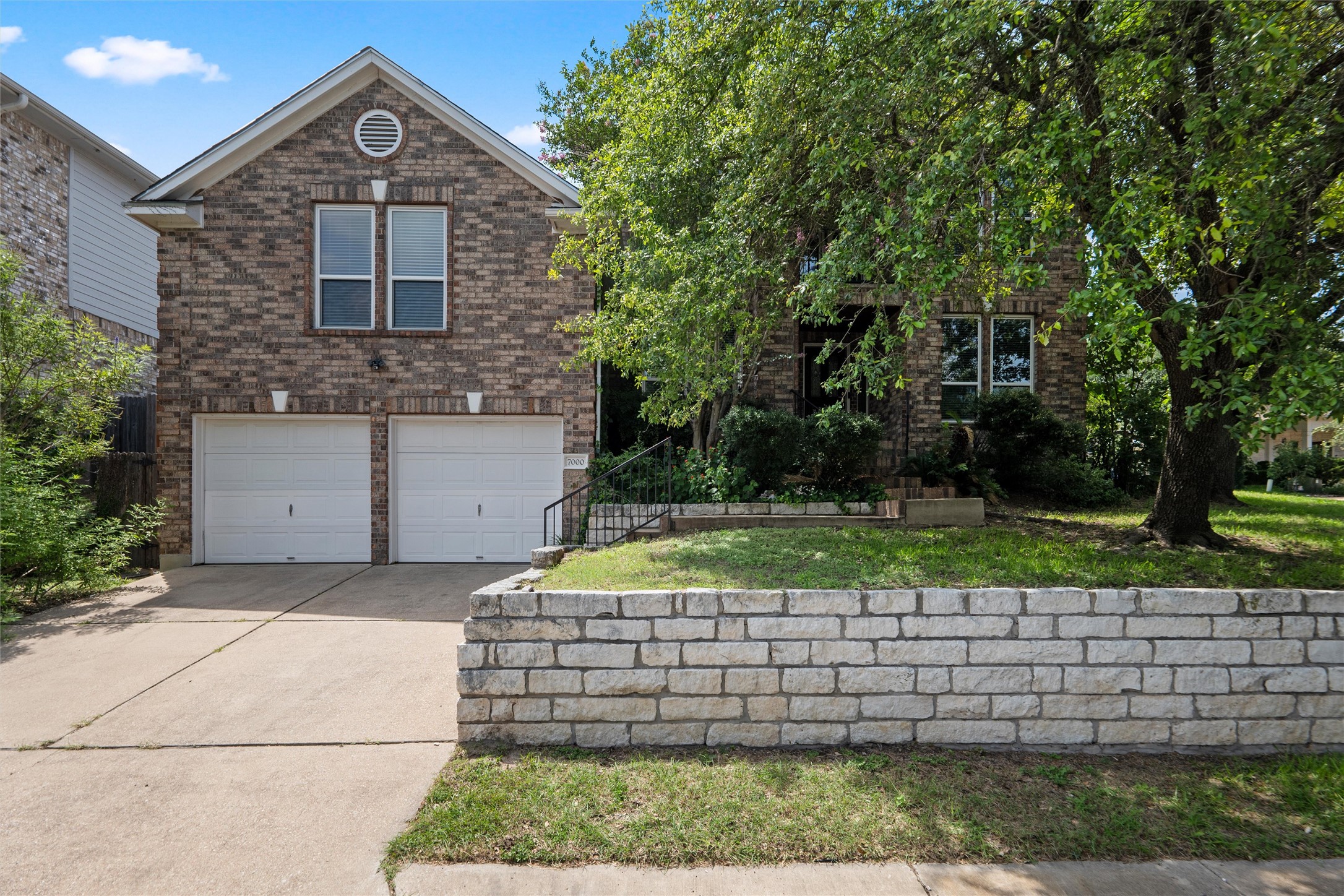7000 Colberg Court Austin, TX 78749 - Photo 3 of 40 A classic brick facade welcomes you home, complete with a two-car garage and mature trees providing ample shade.