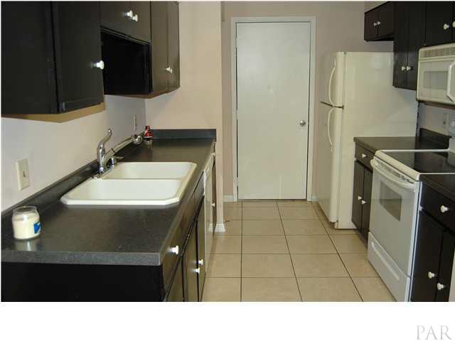 7150 Plantation Road, Unit 413 Pensacola, FL 32504 - Photo 8 of 21 Galley kitchen has solid surface counter, pantry, good cabinet space and accesses the garage