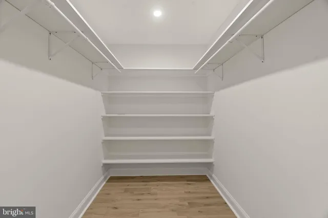 a view of a backyard with a barbeque and large trees