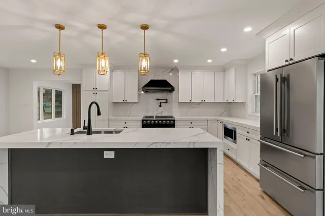 a kitchen with stainless steel appliances granite countertop a sink a stove and a refrigerator