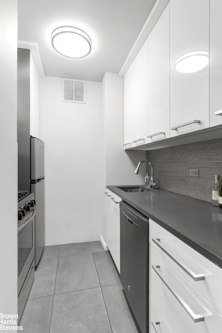 357 East 57th Street, Unit 11E Manhattan, NY 10022 - Photo 3 of 7 a kitchen with granite countertop a sink and a stove