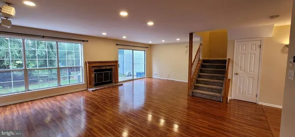 a view of a livingroom with wooden floor and a fireplace