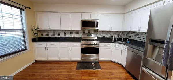 a kitchen with a stove cabinets and a wooden floor
