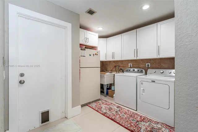 a view of a storage & utility room with a refrigerator
