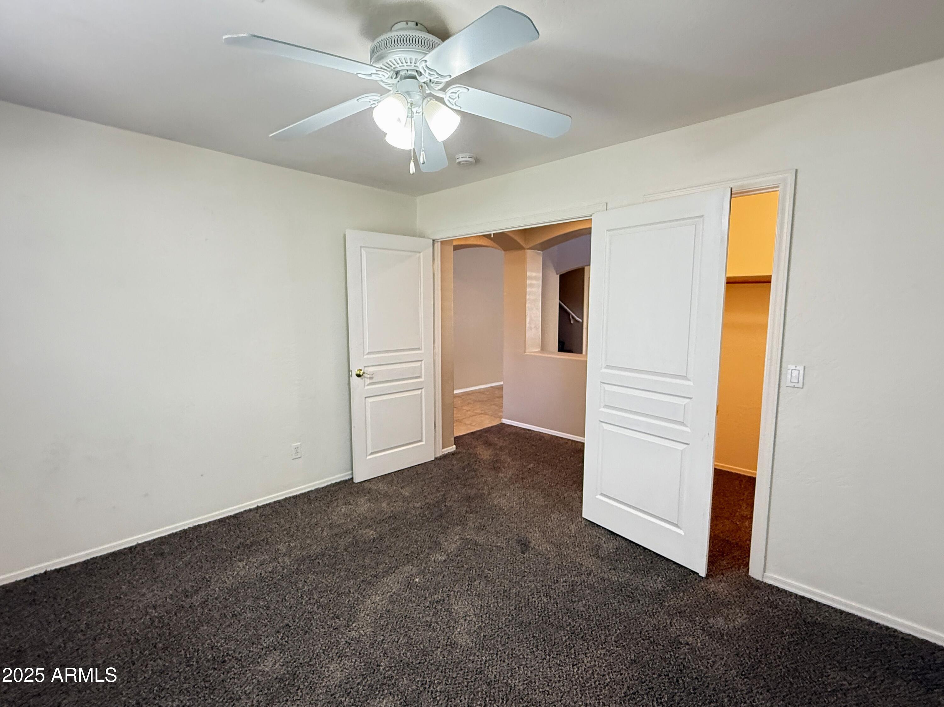 3363 East Flamingo Court Gilbert, AZ 85297 - Photo 15 of 29 an empty room with a ceiling fan and a window