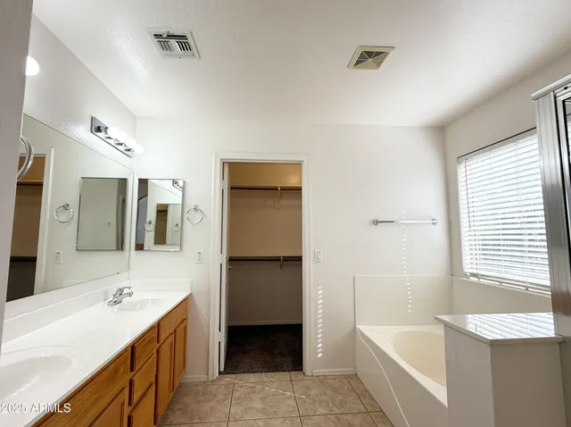 a bathroom with a tub sink and mirror