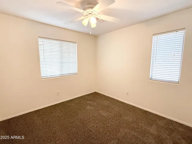 an empty room with a window and a ceiling fan