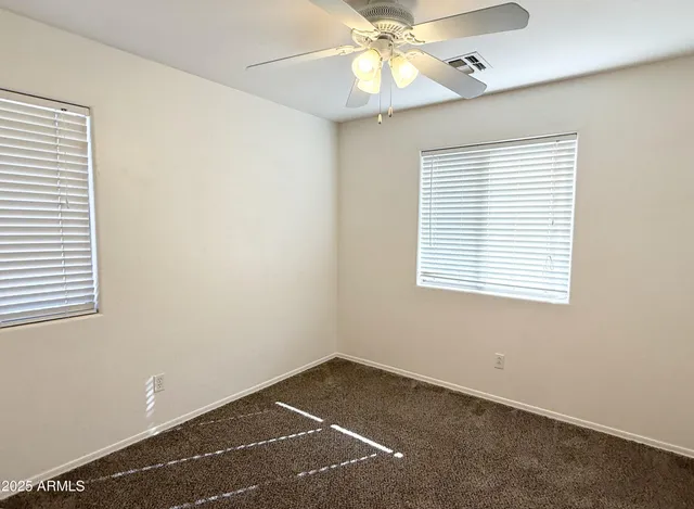 an empty room with a window and a fan