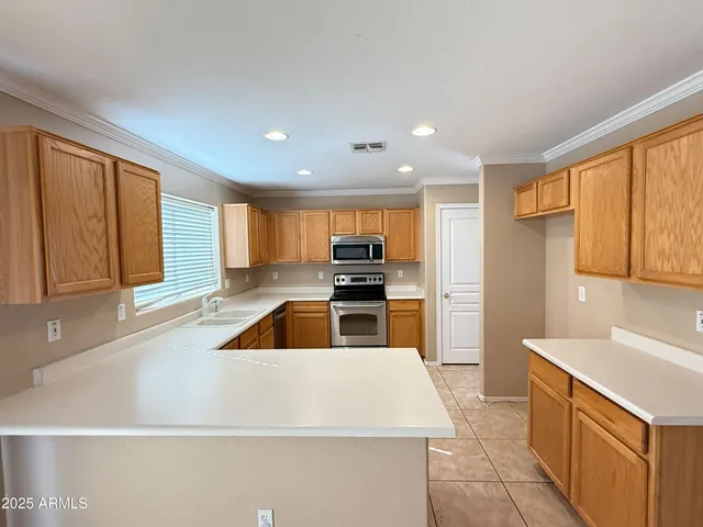 a kitchen with stainless steel appliances kitchen island a large window and a sink