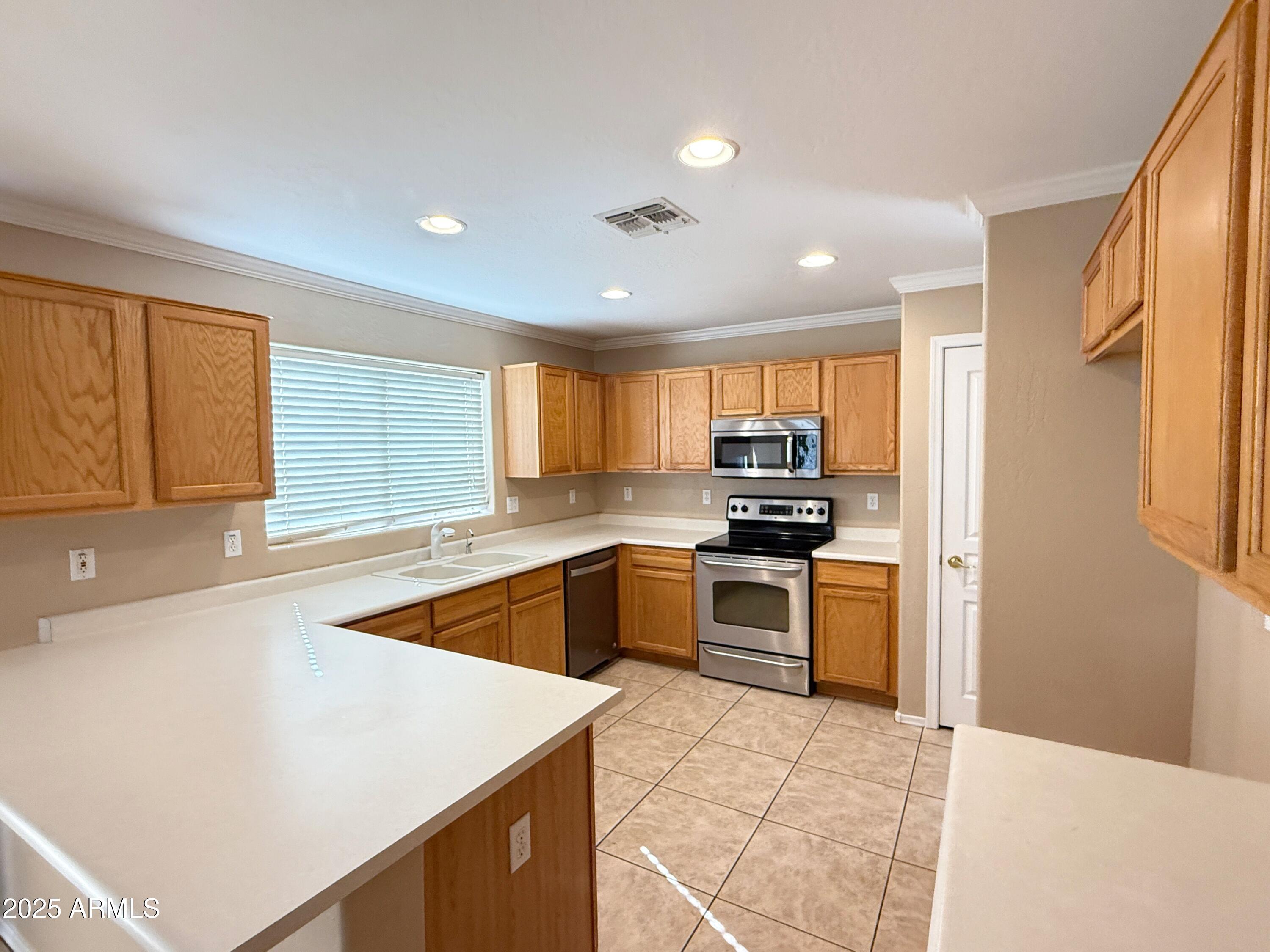 3363 East Flamingo Court Gilbert, AZ 85297 - Photo 8 of 29 a kitchen with a stove a sink and a refrigerator