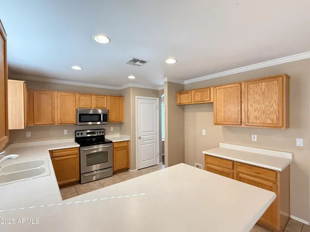 a kitchen with stainless steel appliances granite countertop a stove a sink and a refrigerator