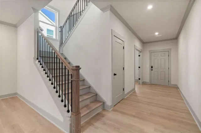 a view of a hallway with wooden floor and staircase