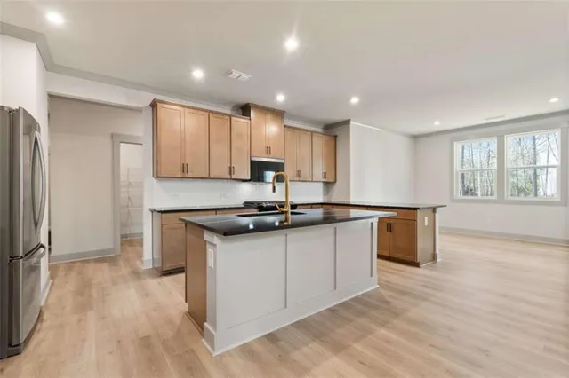 a kitchen with stainless steel appliances granite countertop a sink stove and refrigerator