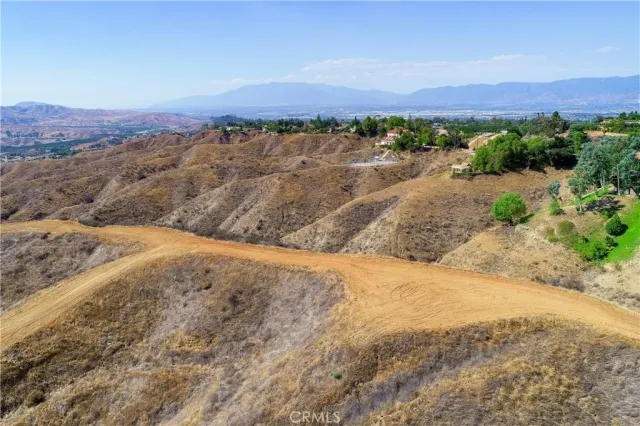 a view of a dry yard with mountains in the background