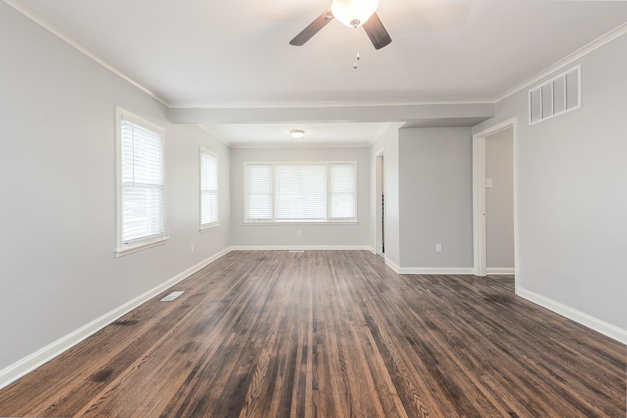 1368 South Perkins Road Memphis, TN 38117 - Photo 8 of 21 an empty room with wooden floor chandelier fan and windows