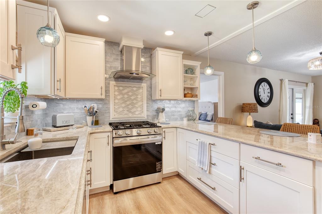 23 Fallon Lane Palm Coast, FL 32137 - Photo 16 of 77 a kitchen with granite countertop a stove a sink and dishwasher with white cabinets