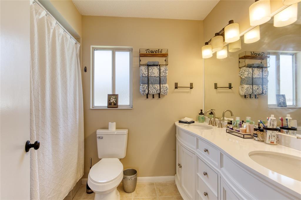 23 Fallon Lane Palm Coast, FL 32137 - Photo 28 of 77 a bathroom with a toilet a sink a mirror a window and vanity