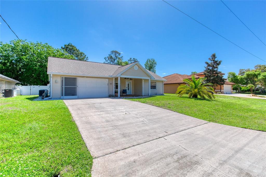 23 Fallon Lane Palm Coast, FL 32137 - Photo 60 of 77 a front view of a house with a yard and garage