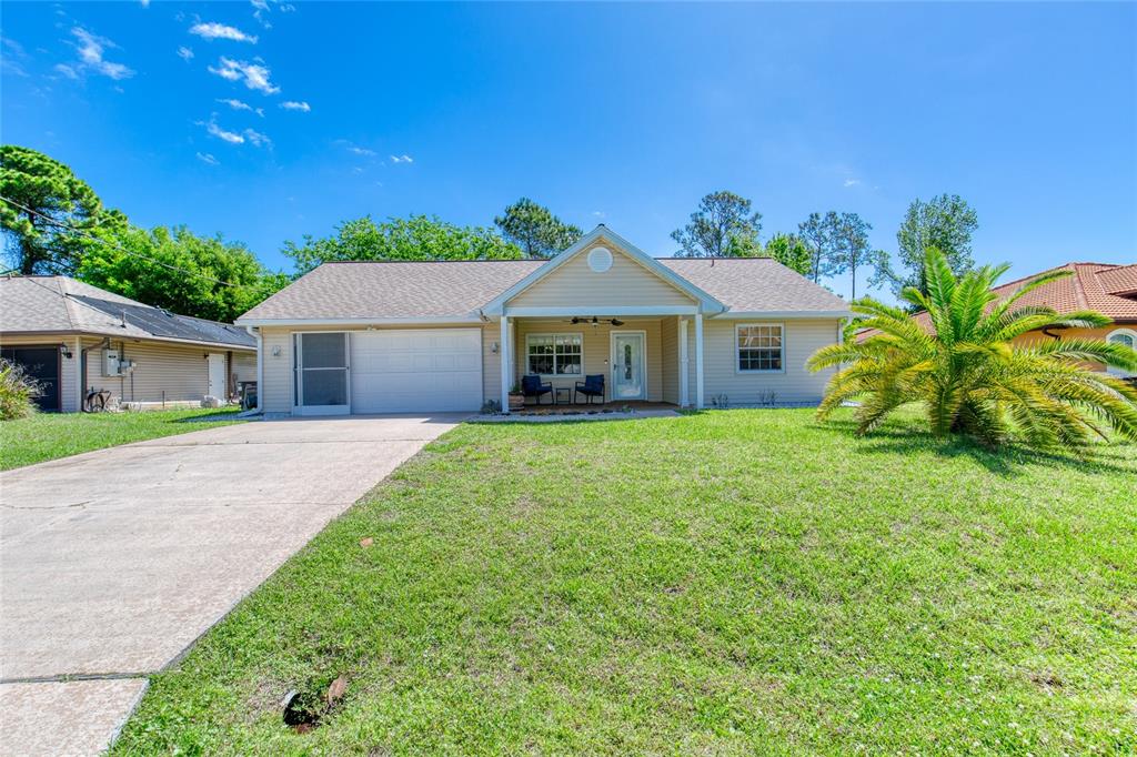 23 Fallon Lane Palm Coast, FL 32137 - Photo 64 of 77 a front view of a house with a garden and yard