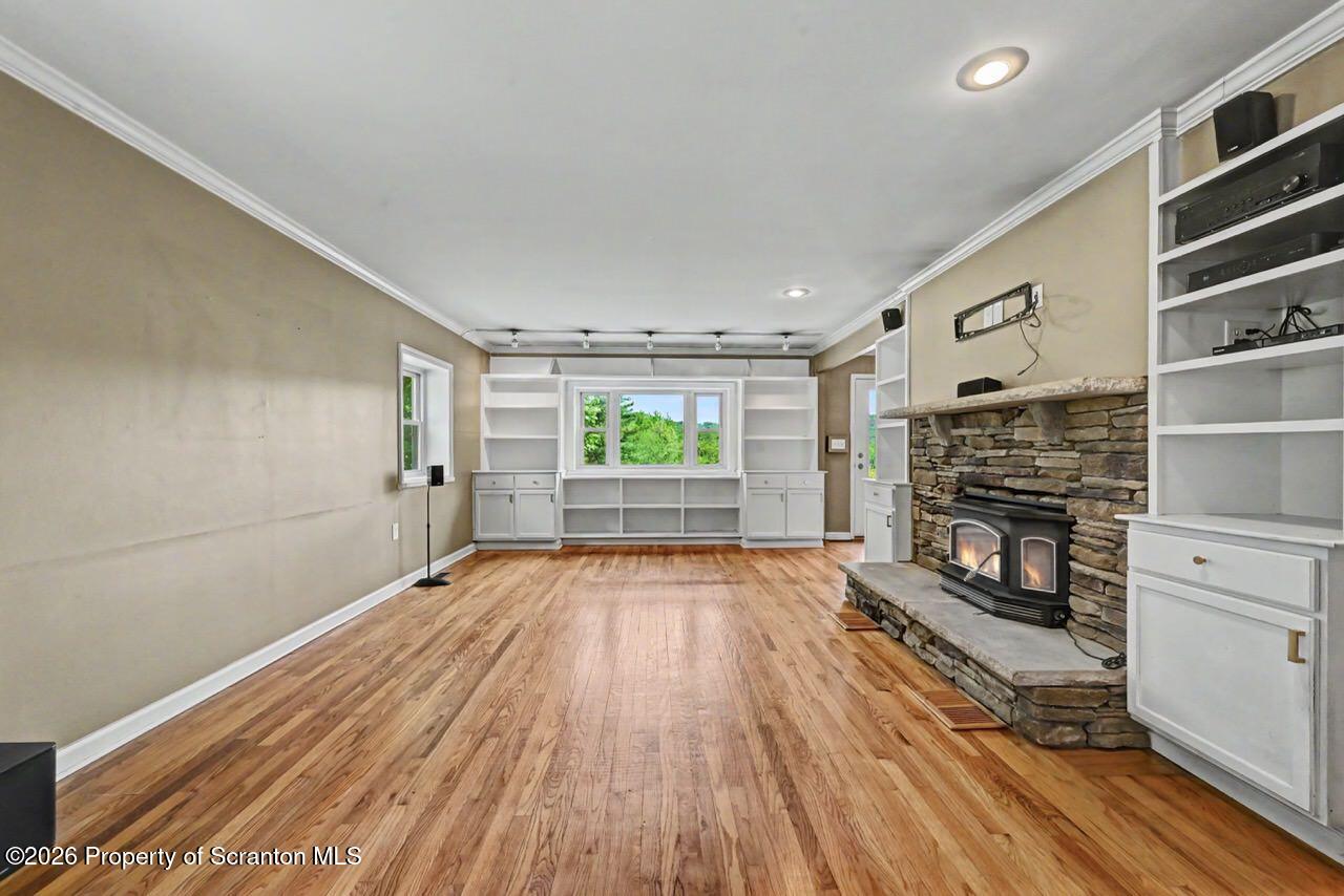 457 Craig Road Dalton, PA 18414 - Photo 22 of 114 a view of wooden floor fireplace and windows in an empty room