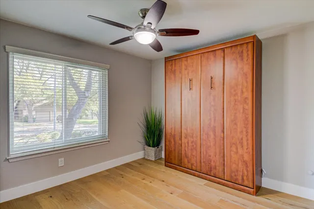 a bedroom with a bed and a ceiling fan