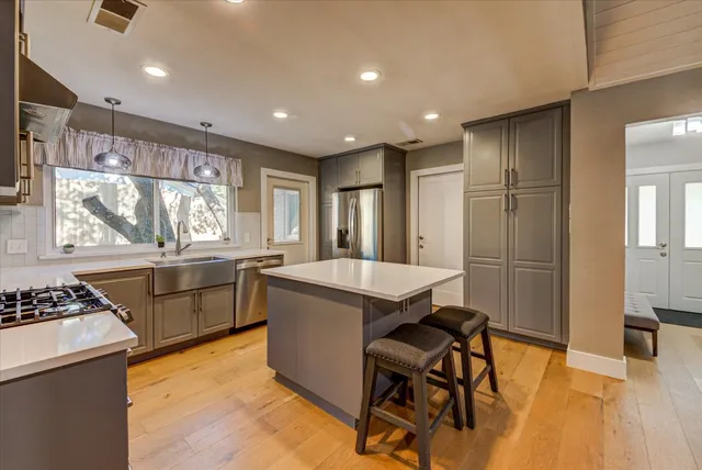 a kitchen with a stove a sink a microwave a dining table and chairs