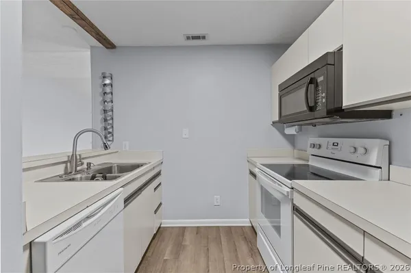 a kitchen with a sink dishwasher stove and microwave