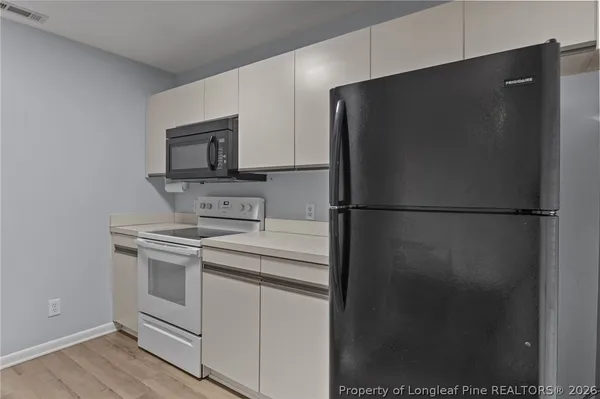 a kitchen with a refrigerator and a stove top oven
