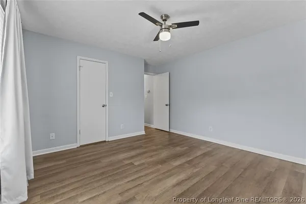 a view of empty room with wooden floor