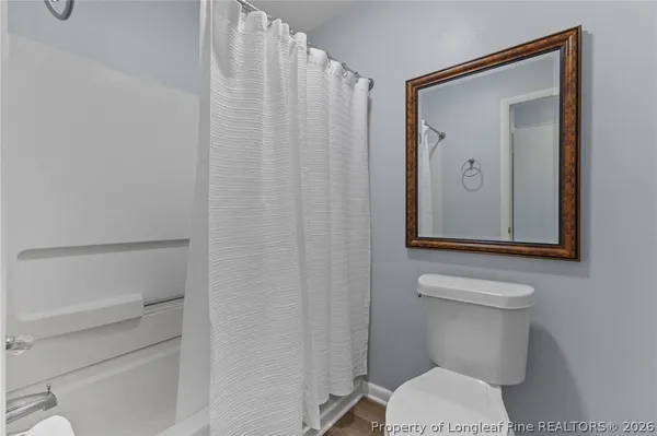 a bathroom with a toilet sink vanity and mirror