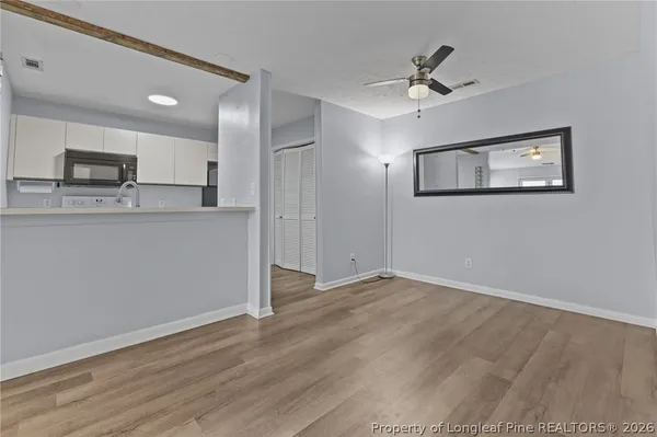 a view of kitchen with stainless steel appliances wooden floor and a refrigerator