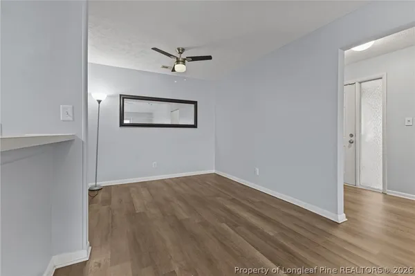 a view of an empty room with wooden floor