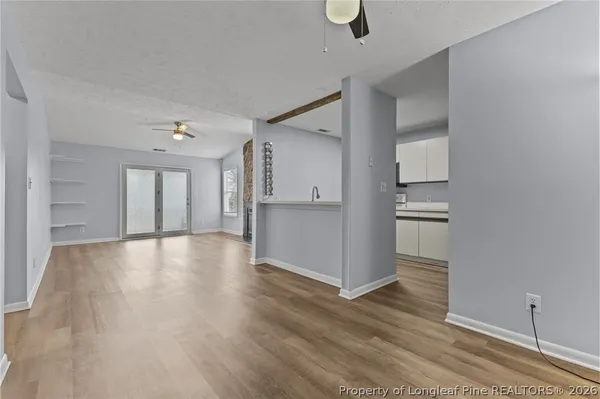 an empty room with wooden floor and windows