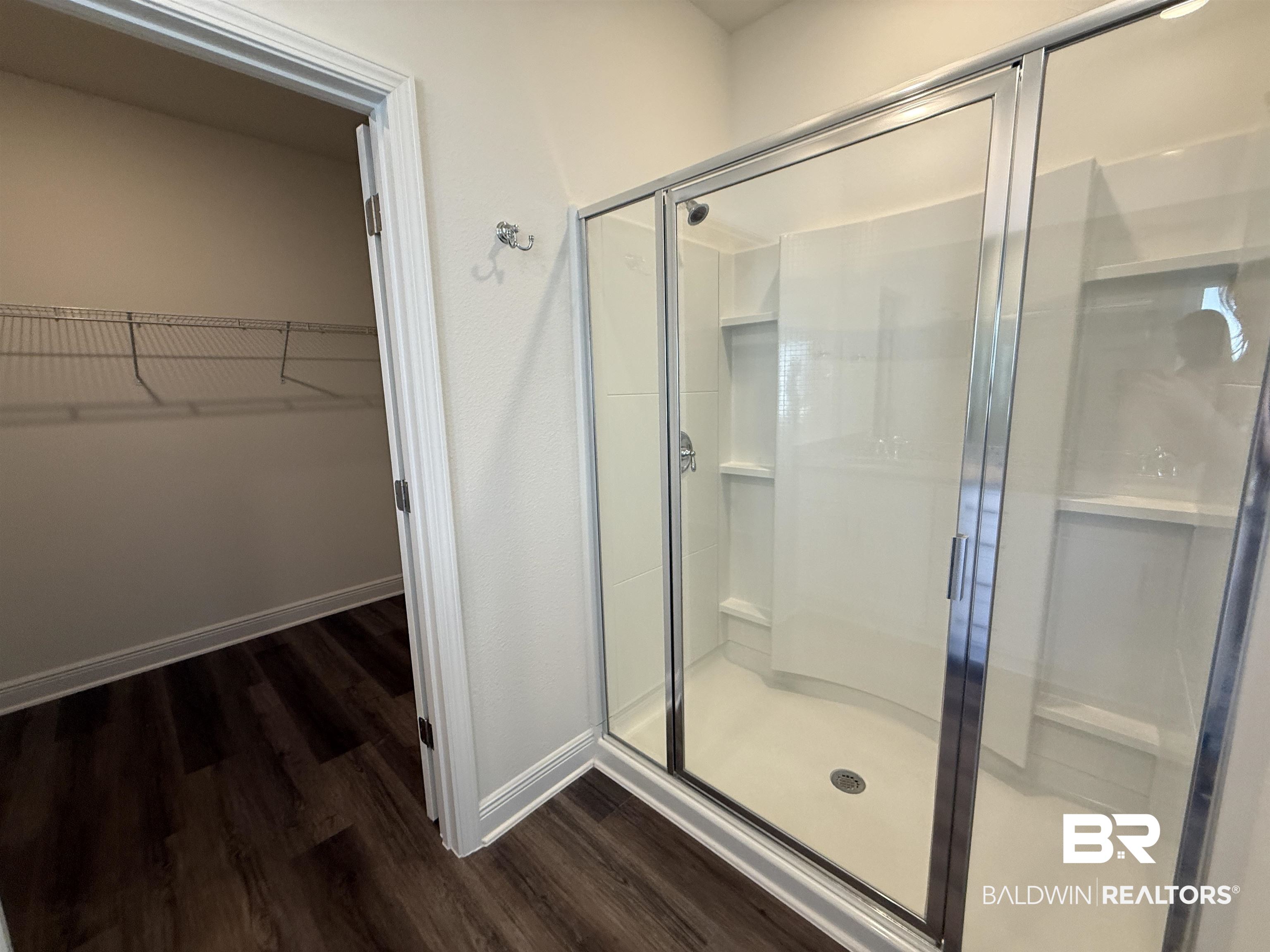 11442 Genuine Risk Circle Daphne, AL 36526 - Photo 12 of 21 Bathroom featuring a walk in closet, a stall shower, and dark wood-style floors