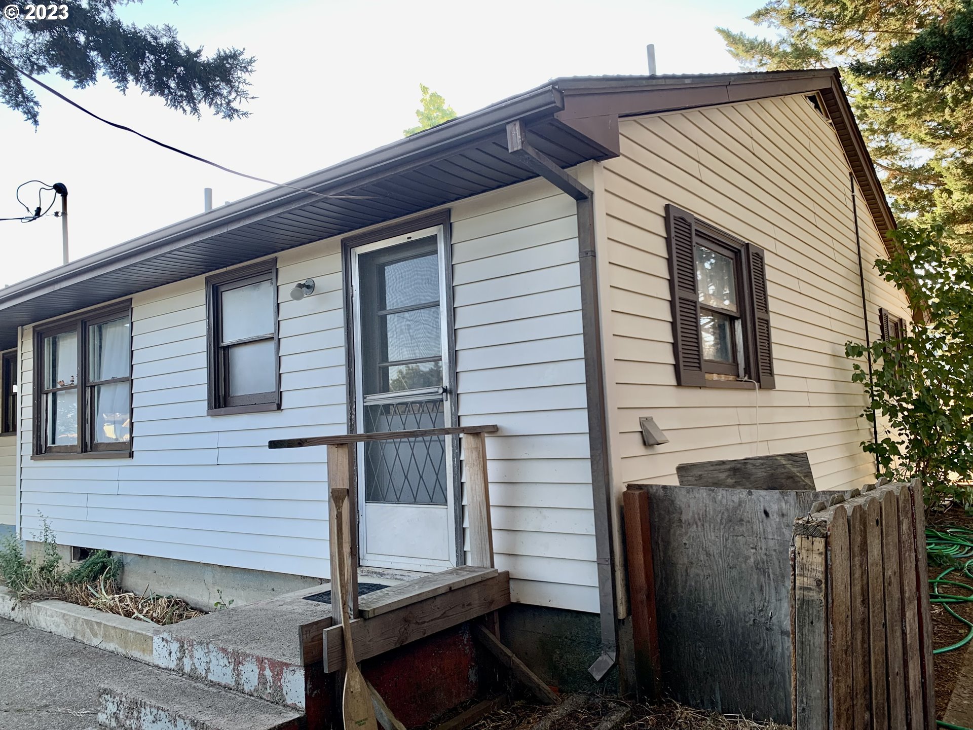 689 East 3rd Avenue Riddle, OR 97469 - Photo 7 of 17 a view of a house with a door and wooden fence