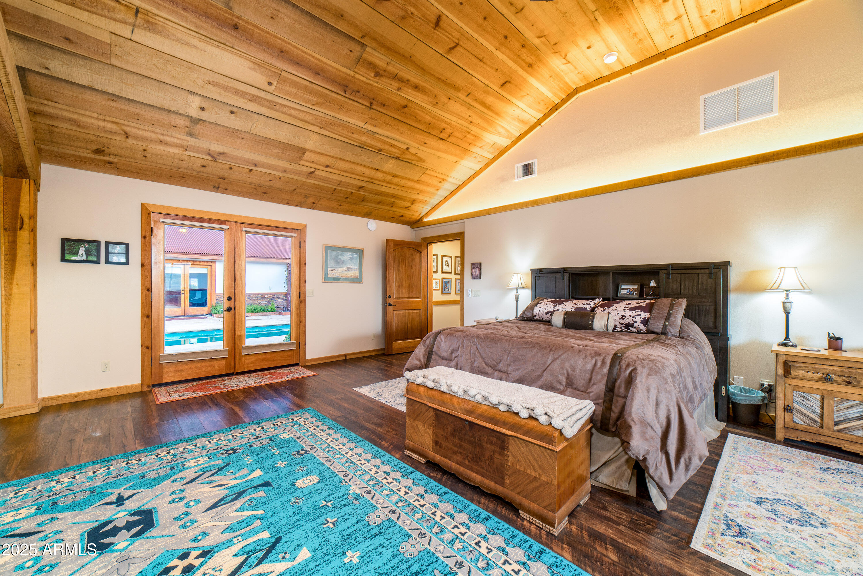 68 Curly Horse Ranch Road Sonoita, AZ 85637 - Photo 17 of 39 a bedroom with a bed and wooden floor