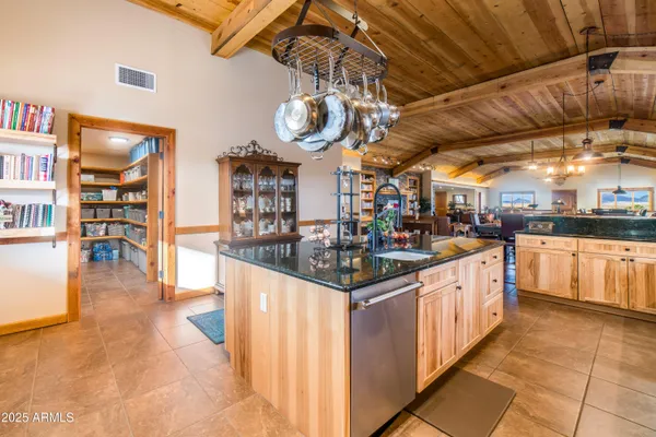 a kitchen with stainless steel appliances a refrigerator and a wooden floor