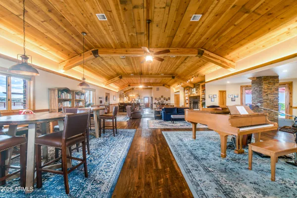 a view of a dining hall with lots of tables a dining table and chairs with wooden floor