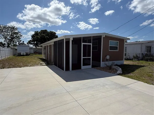 a view of house with backyard and a tree