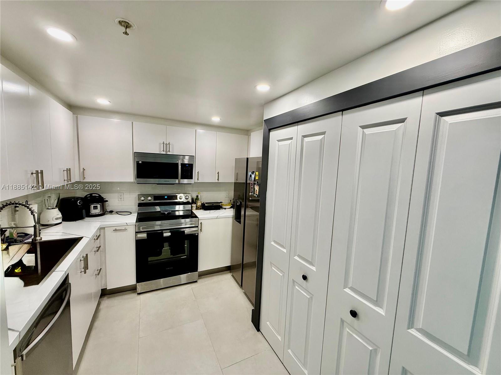 1250 South Miami Avenue, Unit 1603 Miami, FL 33130 - Photo 16 of 44 a kitchen with white cabinets and stainless steel appliances