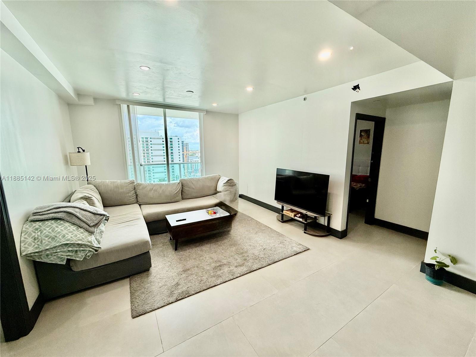 1250 South Miami Avenue, Unit 1603 Miami, FL 33130 - Photo 23 of 44 a living room with furniture and a flat screen tv