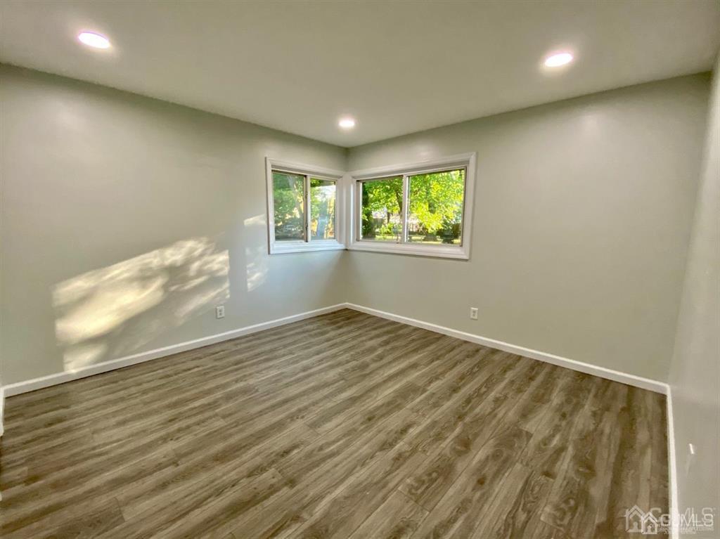 23 Springdale Road Kendall Park, NJ 08824 - Photo 14 of 26 an empty room with wooden floor and windows