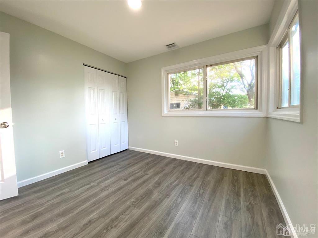 23 Springdale Road Kendall Park, NJ 08824 - Photo 17 of 26 an empty room with wooden floor and windows