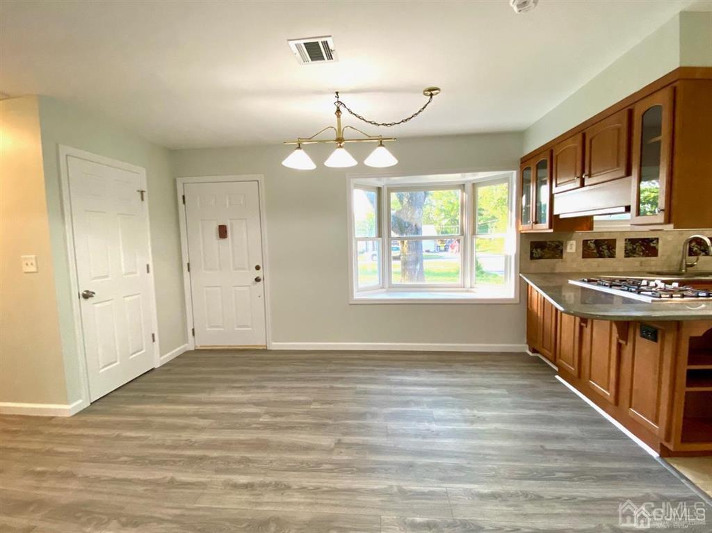 23 Springdale Road Kendall Park, NJ 08824 - Photo 4 of 26 a view of an empty room with window and wooden floor