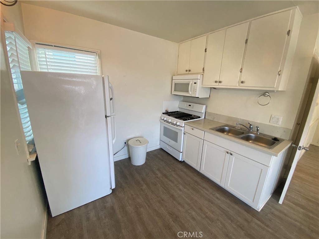 149 Avenida Cabrillo, Unit C San Clemente, CA 92672 - Photo 6 of 8 a kitchen with stainless steel appliances a refrigerator a stove a sink and white cabinets