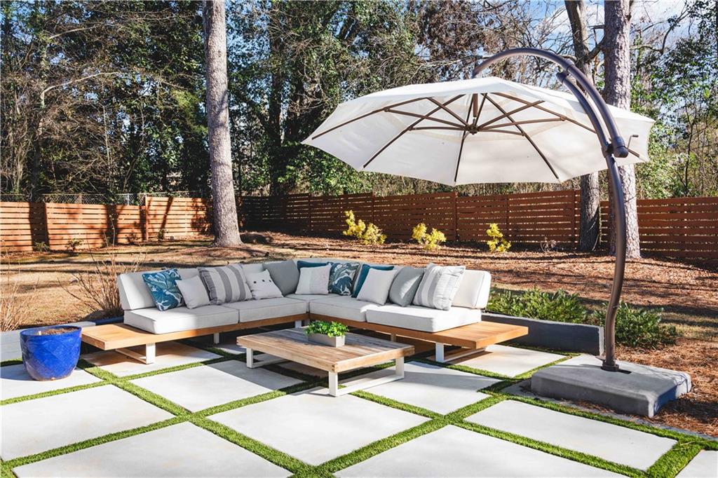 2576 River Oak Drive Decatur, GA 30033 - Photo 40 of 47 a view of a patio with couches table and chairs under an umbrella with a barbeque