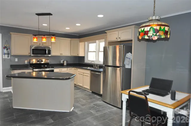 a kitchen with stainless steel appliances granite countertop a stove a sink a refrigerator and a microwave