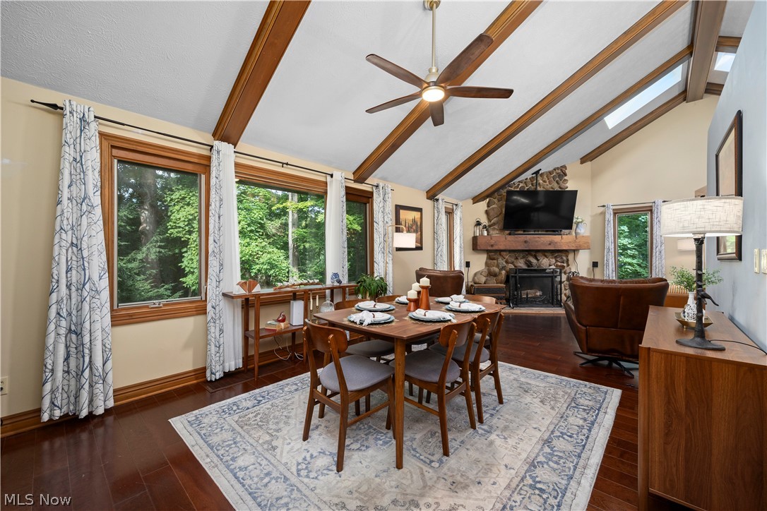 7587 Lewis Road Olmsted Falls, OH 44138 - Photo 6 of 50 Vaulted ceiling with exposed wood beams, skylights, wood-finish flooring, and a stone-clad fireplace with a wood mantle