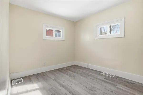a view of a room with wooden floor and a window
